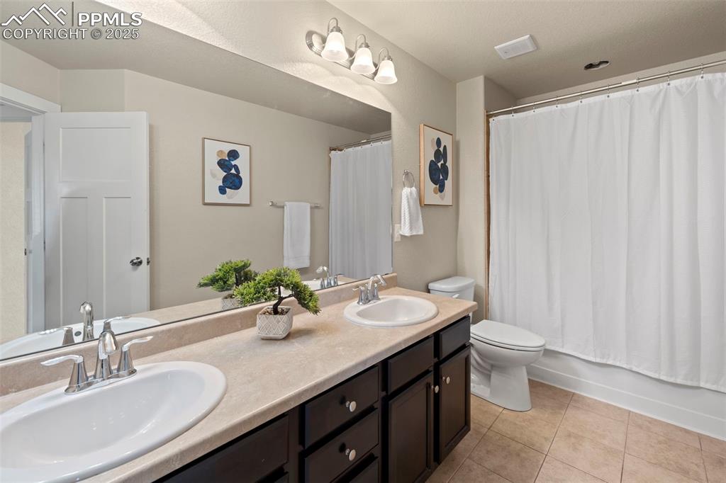 Image 25 of 31: Bathroom with double vanity and tub/shower 