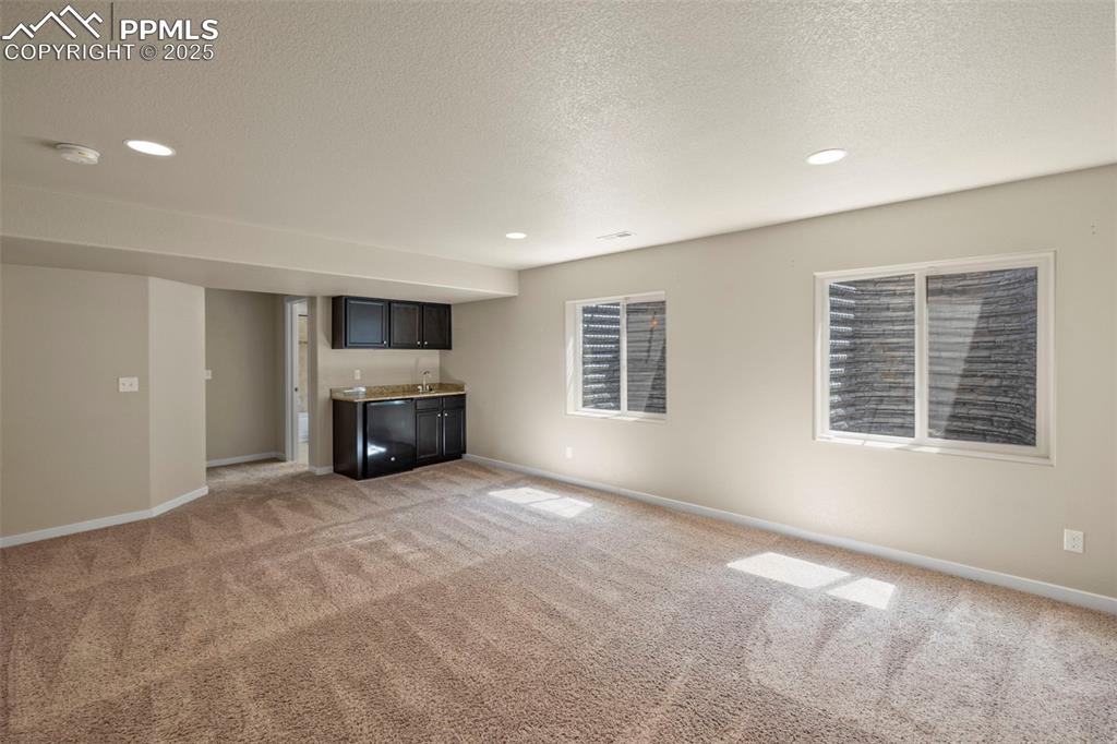 Image 26 of 31: Basement family room with wet bar