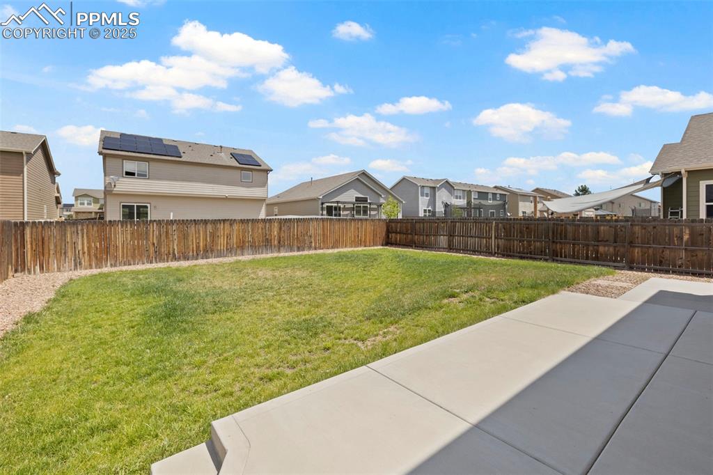 Image 31 of 31: Nice flat backyard with grass and sprinkler system