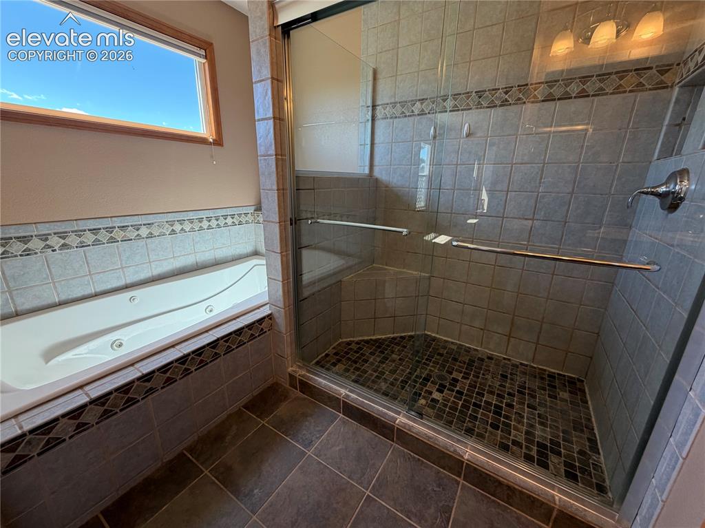 Image 16 of 21: Primary Bath Soaking Tub and Walk in Shower