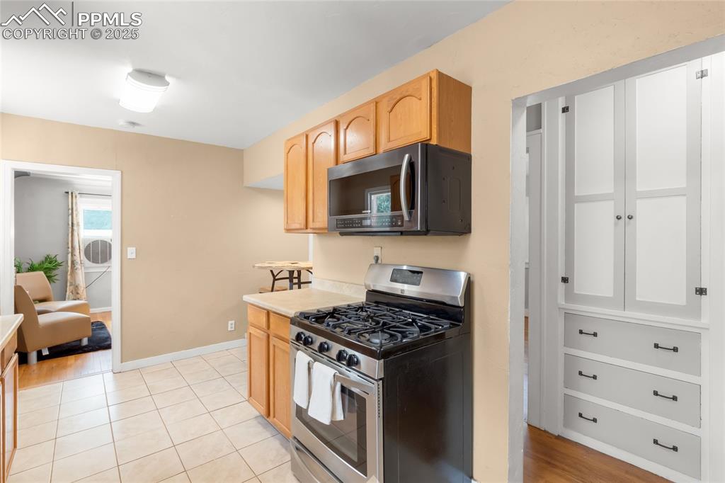 Image 13 of 39: Kitchen with stainless steel appliances, light countertops, light brown cab