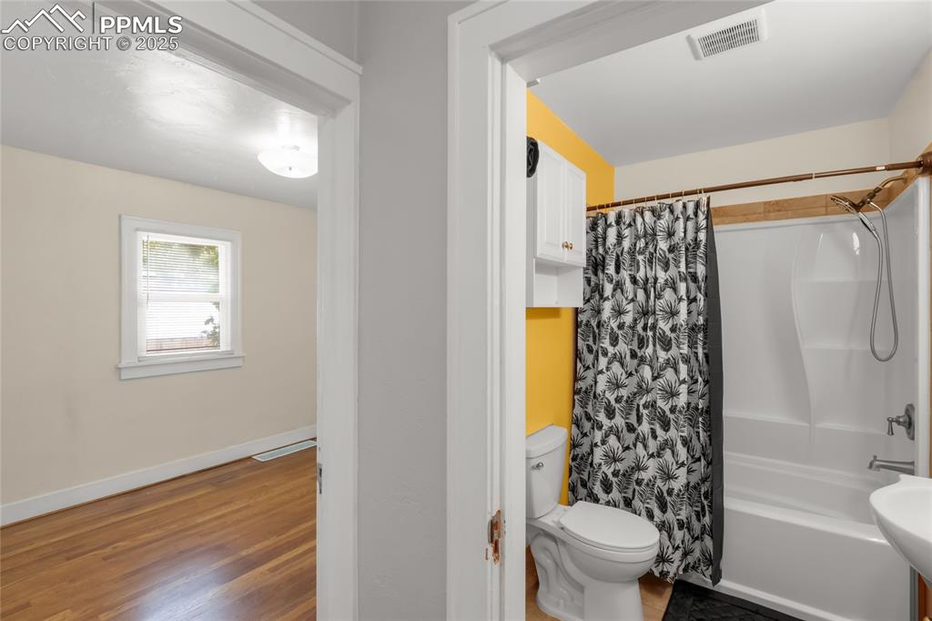 Image 16 of 39: Full bath featuring wood finished floors and shower / bath combo