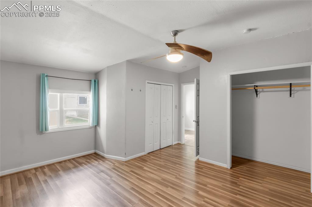 Image 27 of 39: Unfurnished bedroom featuring light wood-style floors, two closets, and cei