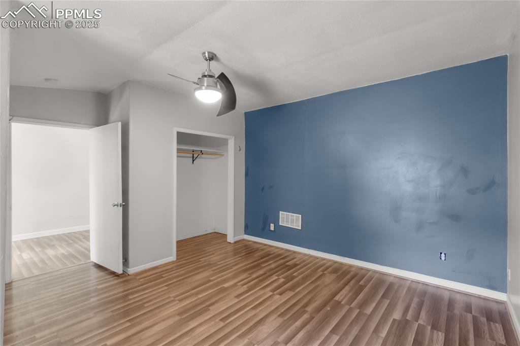 Image 29 of 39: Unfurnished bedroom with wood finished floors, a closet, and a ceiling fan