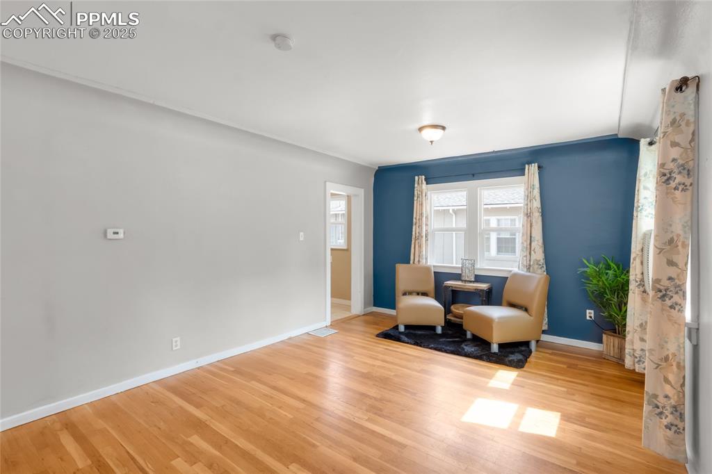 Image 5 of 39: Sitting room with wood finished floors