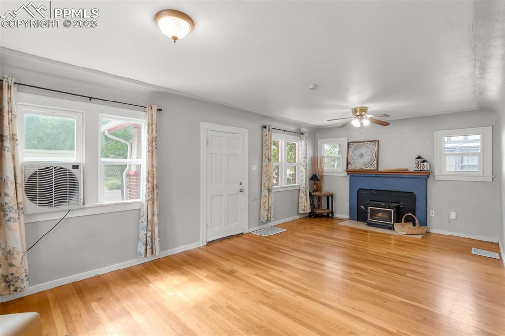 Image 9 of 39: Unfurnished living room with wood finished floors, healthy amount of natura