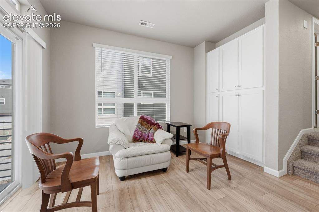 Image 15 of 24: Dining area or sitting room with built-in cabinets and sliding door to the
