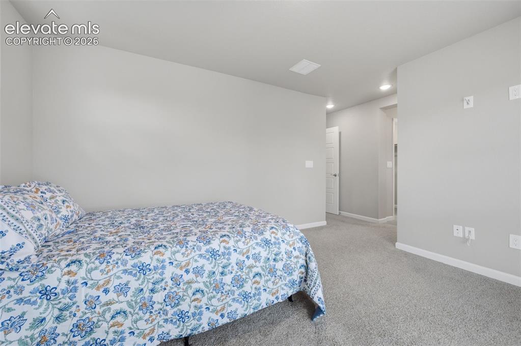 Image 18 of 24: Primary bedroom suite is carpetedCarpeted room with a recessed ceiling ligh