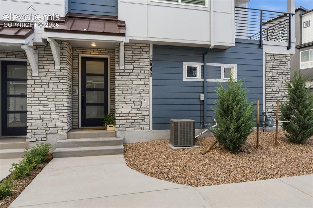 Image 24 of 24: Modern townhome exterior featuring stone veneer, blue horizontal siding, an
