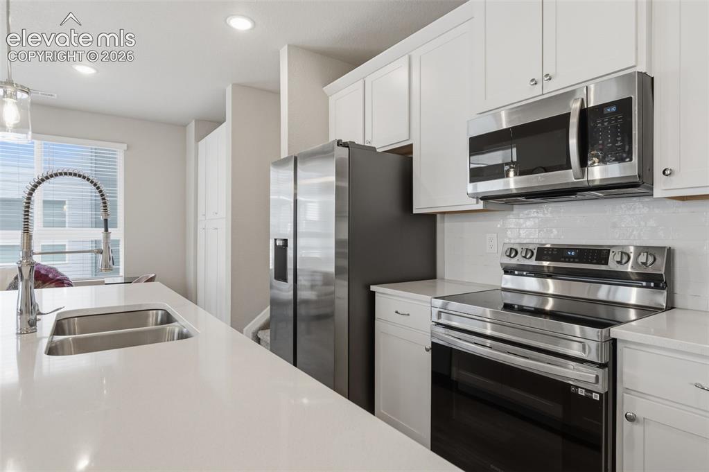 Image 3 of 24: Modern kitchen featuring a double basin stainless steel sink with a high-ar