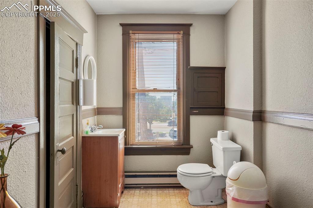 Image 19 of 28: Bathroom with baseboard heating and vanity