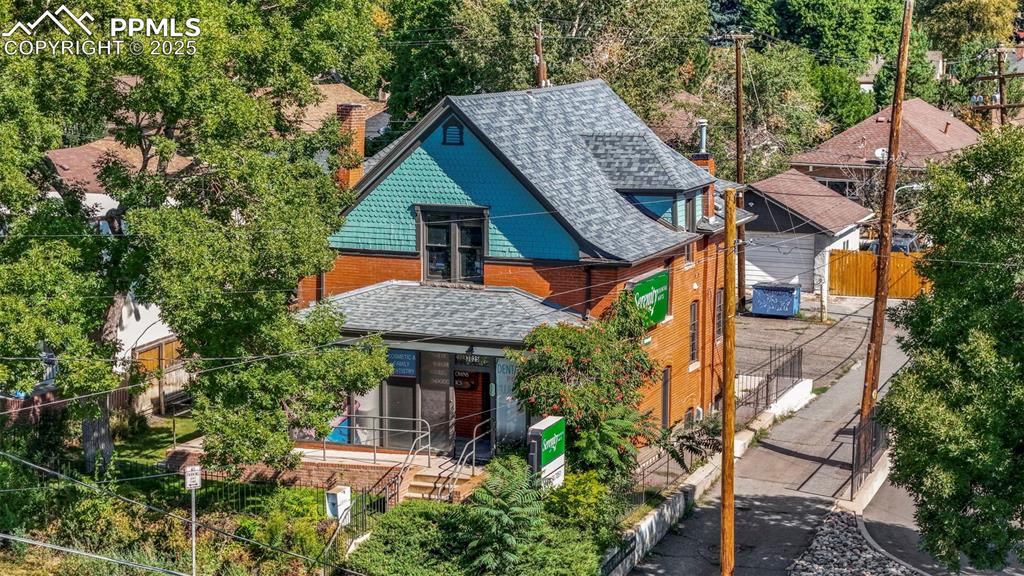 Image 22 of 28: View of front of property with a shingled roof and brick siding