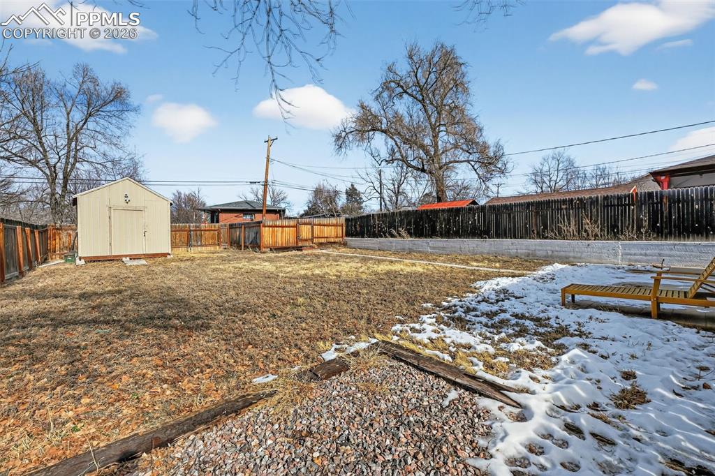 Image 20 of 34: Back yard with storage shed and alley access