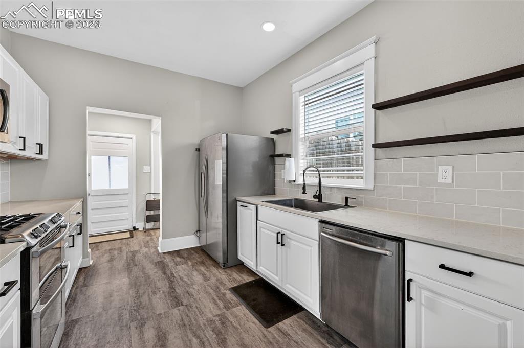 Image 9 of 34: Large kitchen with quartz countertops and under-cabinet lighting