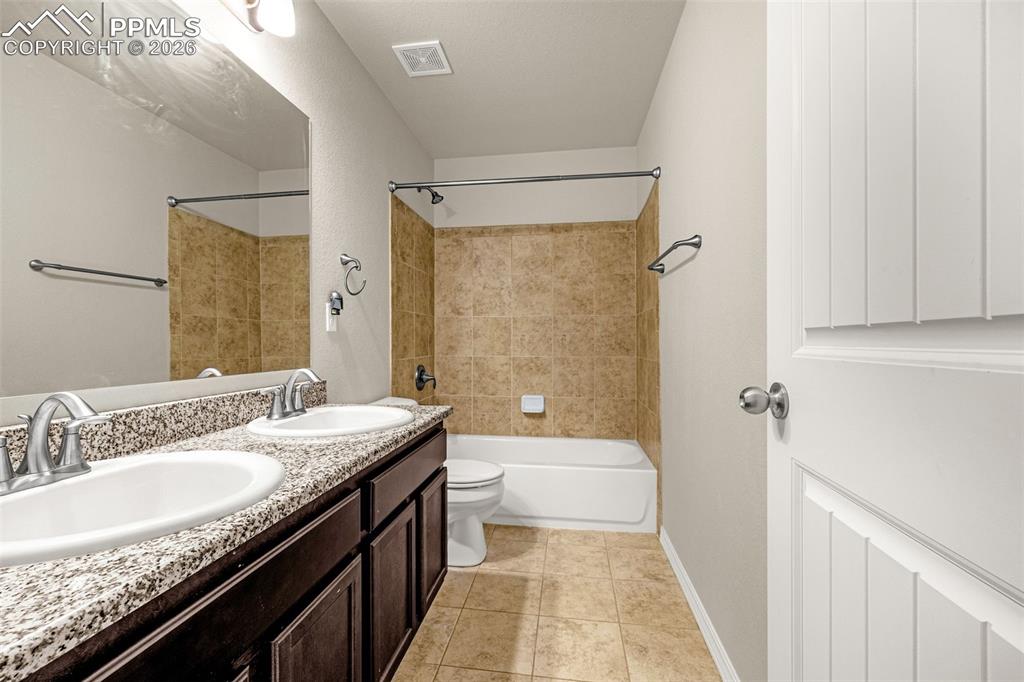 Image 30 of 37: Secondary bathroom with double sinks