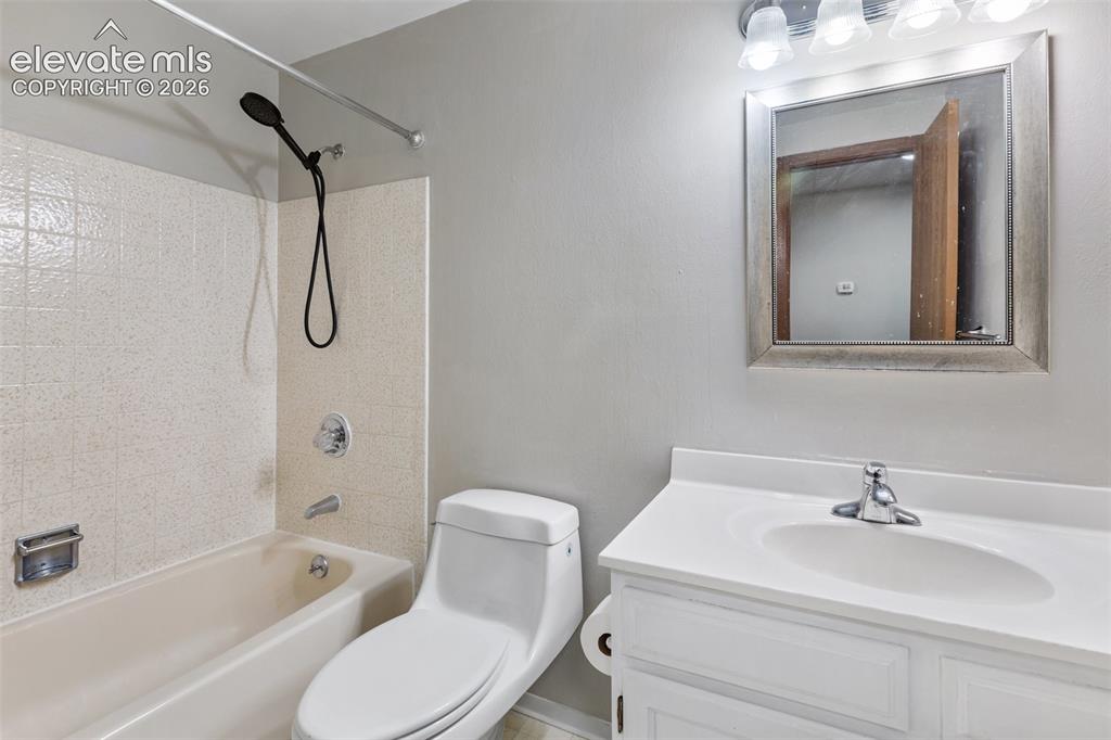 Image 12 of 27: Integrated white vanity with chrome faucet, a framed mirror, and a three-li