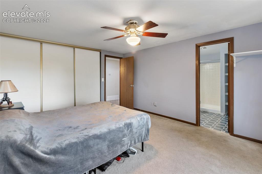 Image 27 of 27: Carpeted room featuring a ceiling fan with integrated lighting, sliding clo