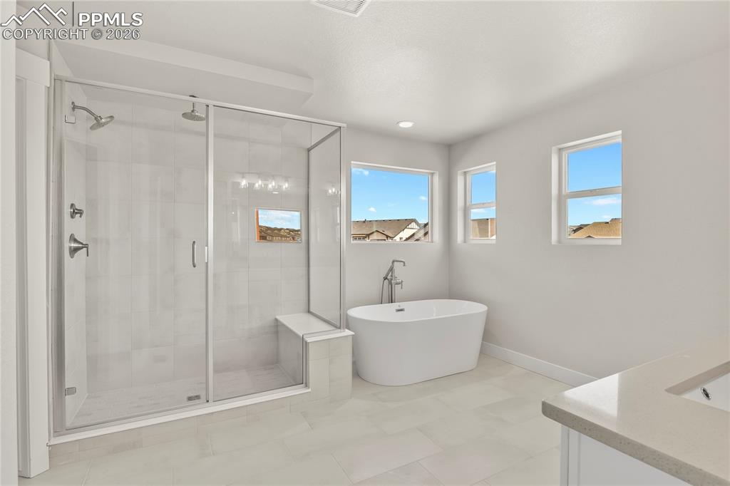 Image 25 of 43: Five-piece bath finished with soaker tub and large shower with bench