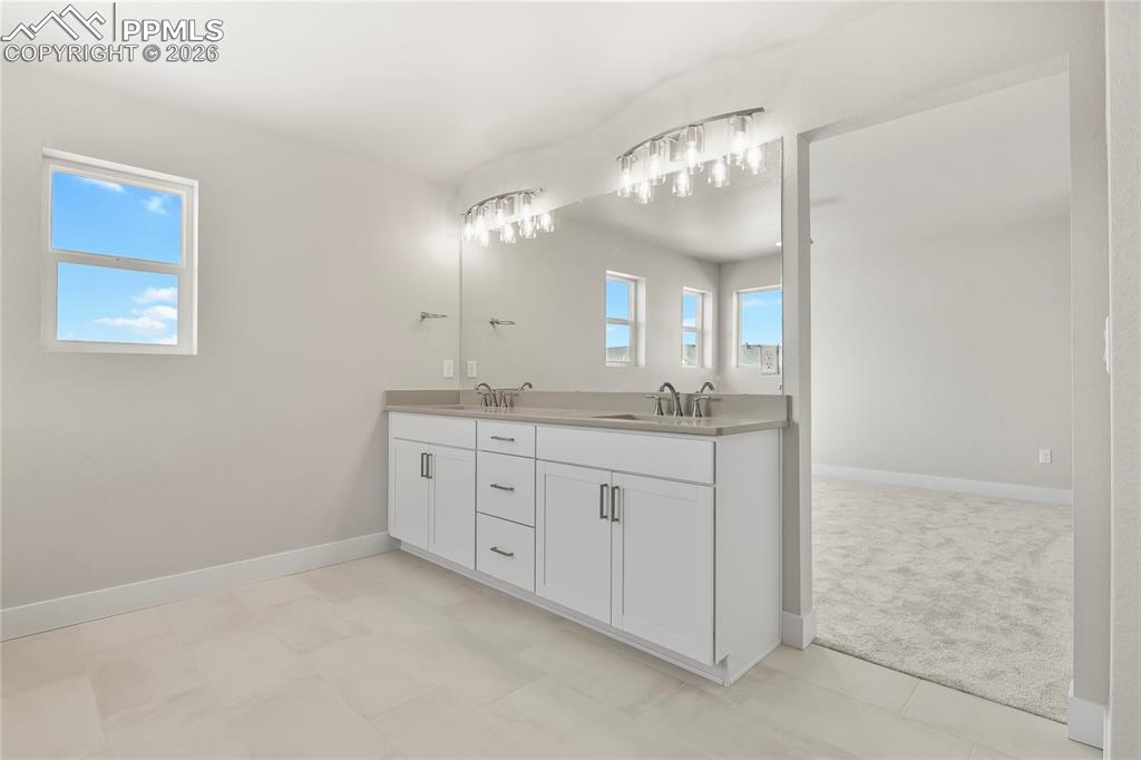 Image 26 of 43: Five-piece bath finished with quartz counters and dual vanity
