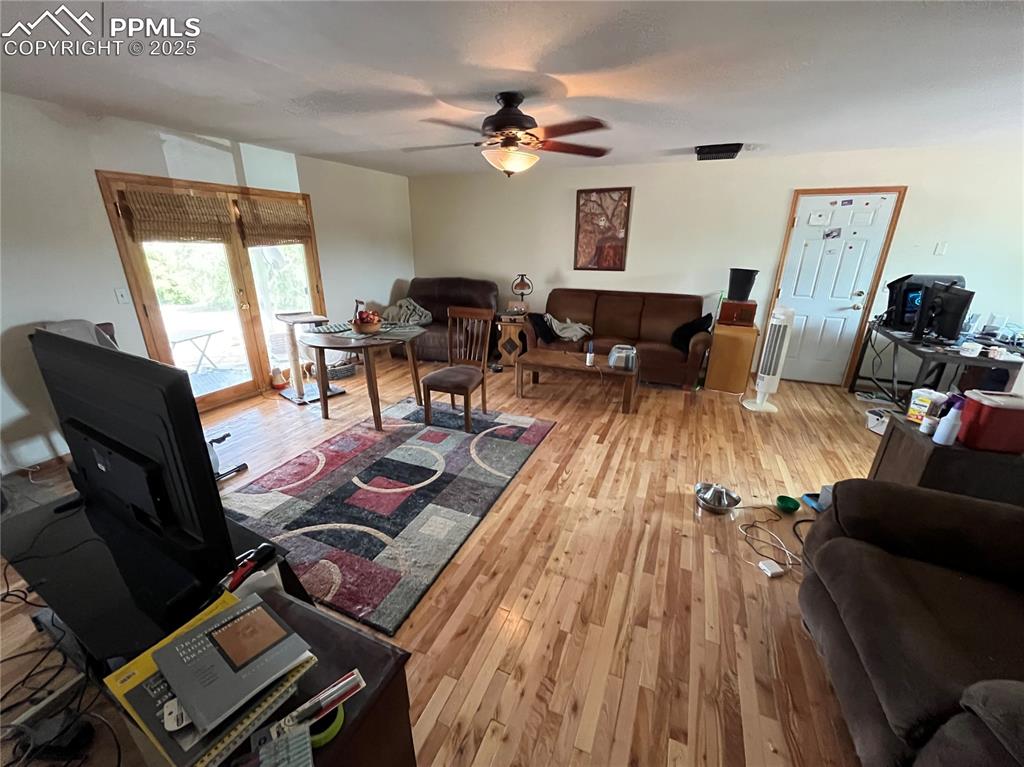 Image 10 of 21: French doors in the Living Room open to a partially covered backyard patio,