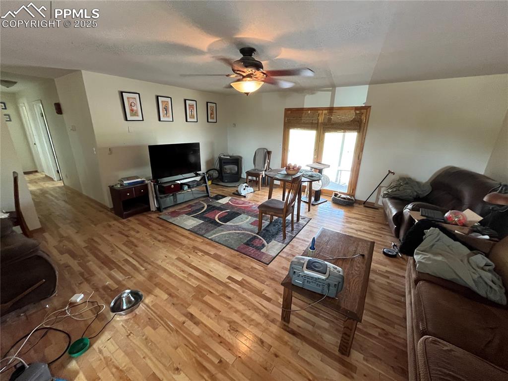 Image 9 of 21: Relax in the spacious living room with a lighted ceiling fan and French doo