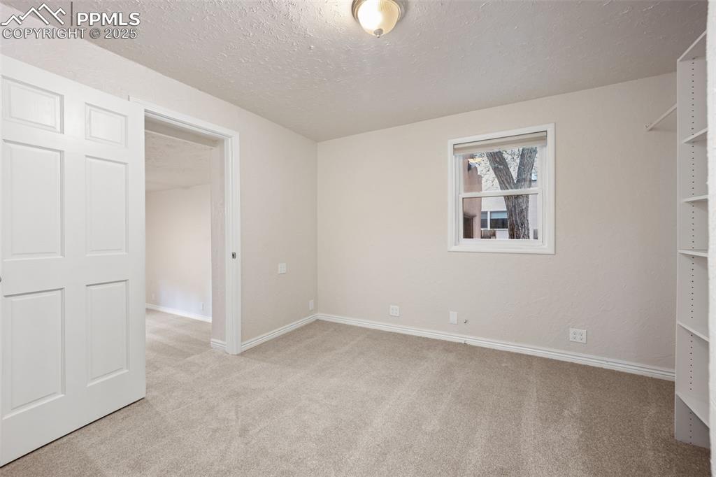 Image 17 of 31: Unfurnished bedroom with light colored carpet and a textured ceiling