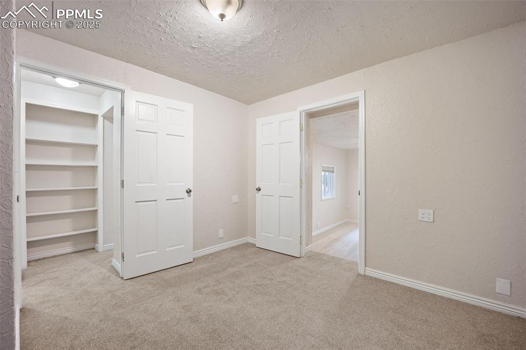Image 20 of 31: Unfurnished bedroom featuring light carpet, a textured ceiling, and a textu