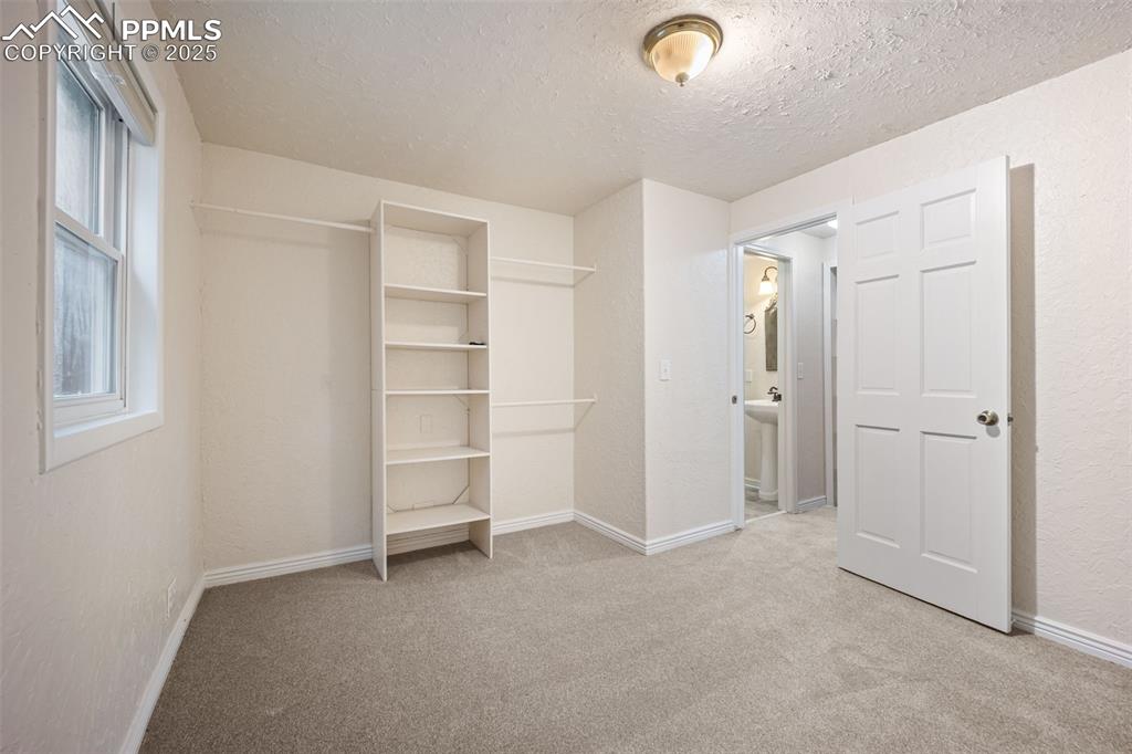 Image 21 of 31: Unfurnished bedroom with carpet floors, a textured wall, a textured ceiling