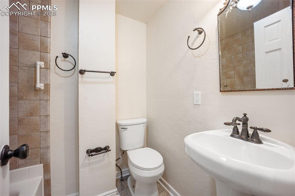 Image 22 of 31: Bathroom featuring a sink and a textured wall