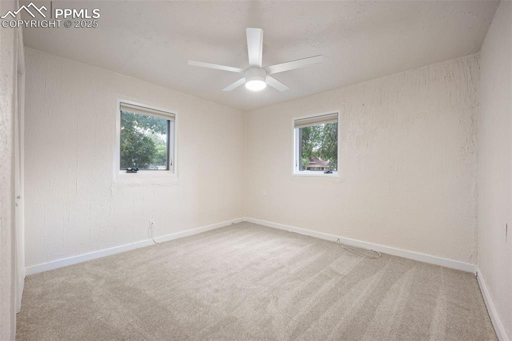 Image 23 of 31: Carpeted spare room with baseboards and a ceiling fan