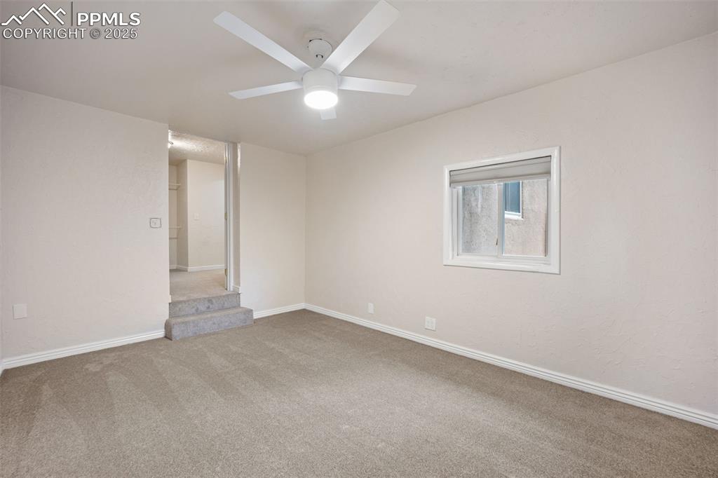 Image 27 of 31: Carpeted spare room with baseboards and ceiling fan