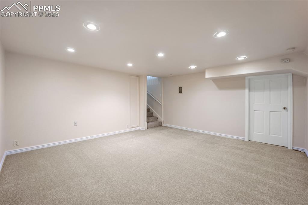 Image 29 of 31: Finished below grade area with recessed lighting, light carpet, and stairs