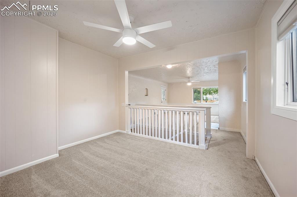 Image 8 of 31: Carpeted spare room with a textured ceiling and ceiling fan