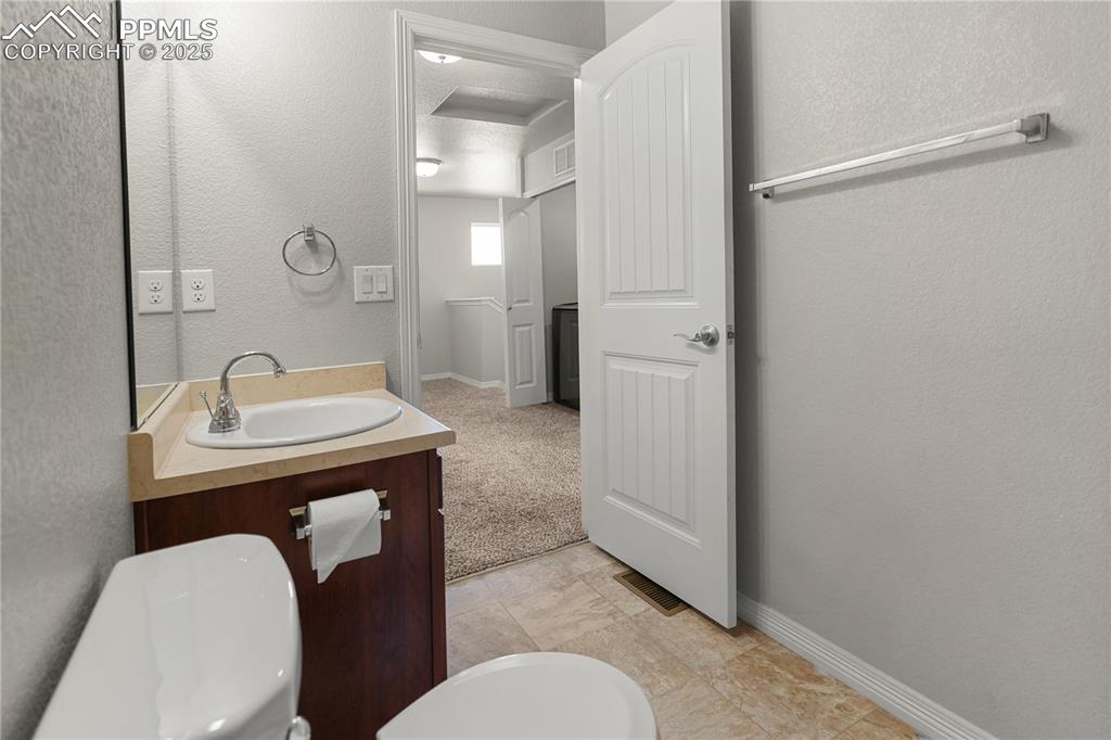 Image 12 of 22: Bathroom featuring vanity and a textured wall