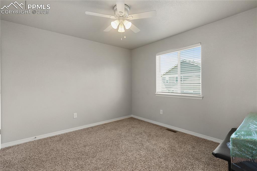Image 13 of 22: Unfurnished room featuring carpet and ceiling fan