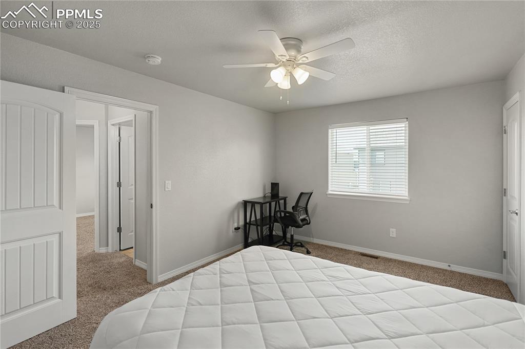 Image 15 of 22: Carpeted bedroom with a ceiling fan and a textured ceiling