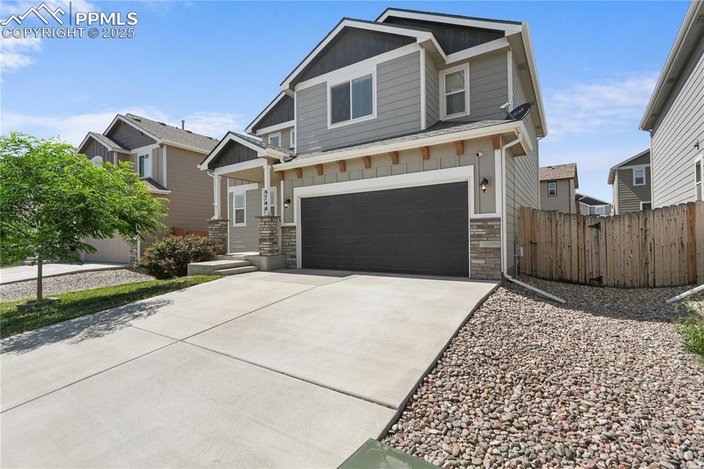 Image 2 of 22: Craftsman-style home with board and batten siding, a garage, stone siding,