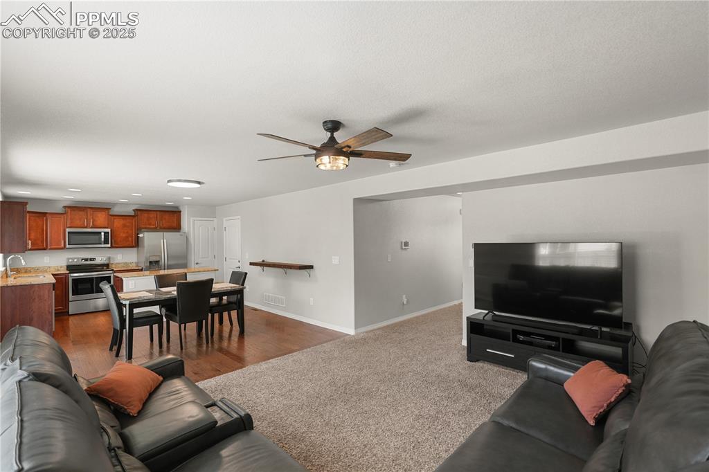 Image 7 of 22: Living area with a ceiling fan and recessed lighting