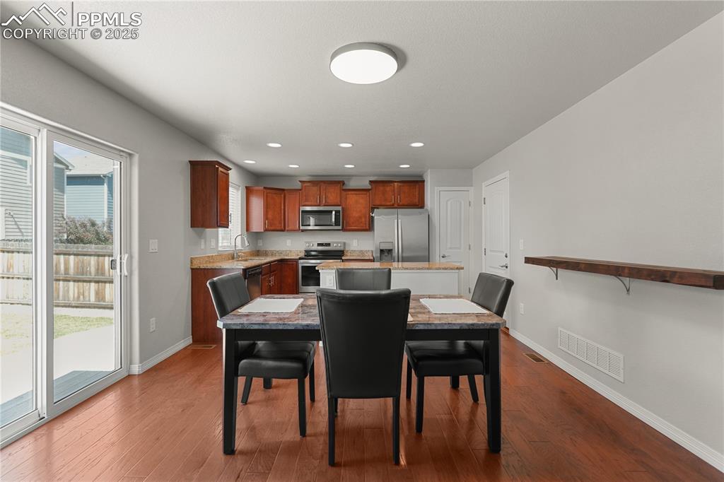 Image 8 of 22: Dining area with dark wood-type flooring and recessed lighting