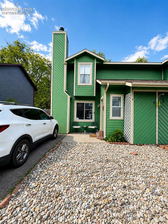 Image 1 of 27: Green exterior siding with white trim, featuring a prominent chimney struct