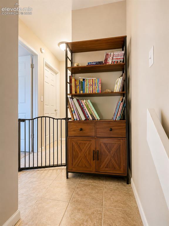 Image 17 of 27: Hallway featuring light-toned tile flooring and neutral wall paint