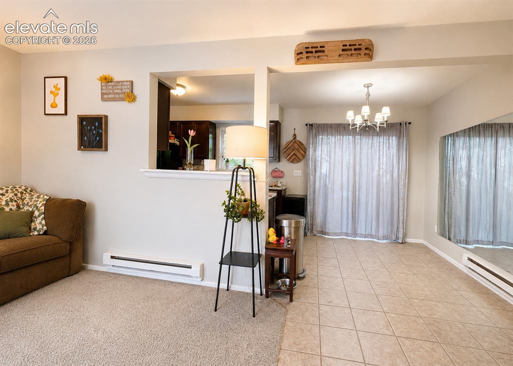 Image 4 of 27: Combined living area featuring beige carpet, light neutral wall paint, and 
