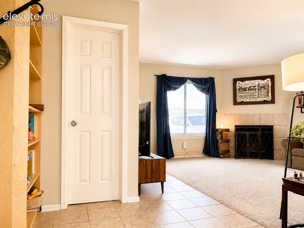 Image 7 of 27: Spacious interior featuring a tiled entry, light-toned carpeting, and a fir