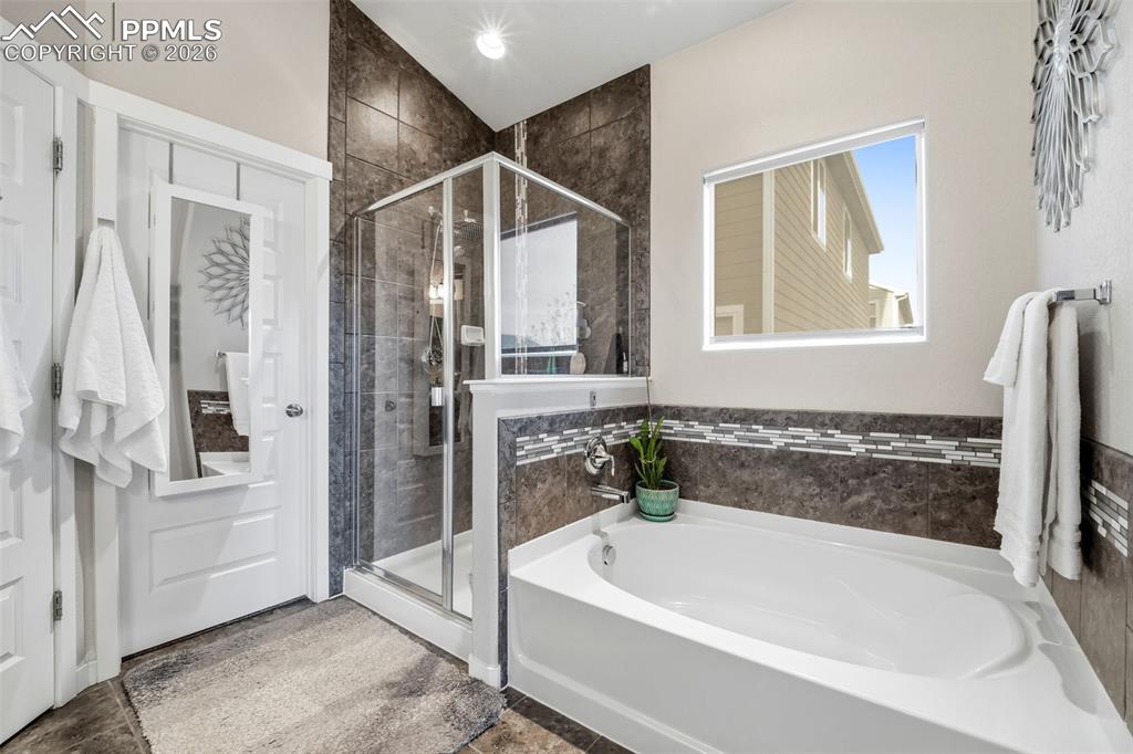 Image 27 of 50: Full bathroom with a shower stall and a garden tub
