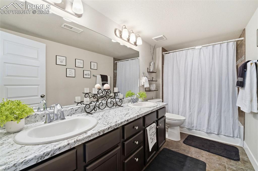Image 38 of 50: Full bath featuring double vanity and shower / bath combo