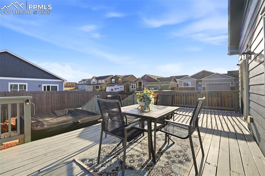 Image 40 of 50: Wooden deck featuring a residential view, outdoor dining area, and a fenced