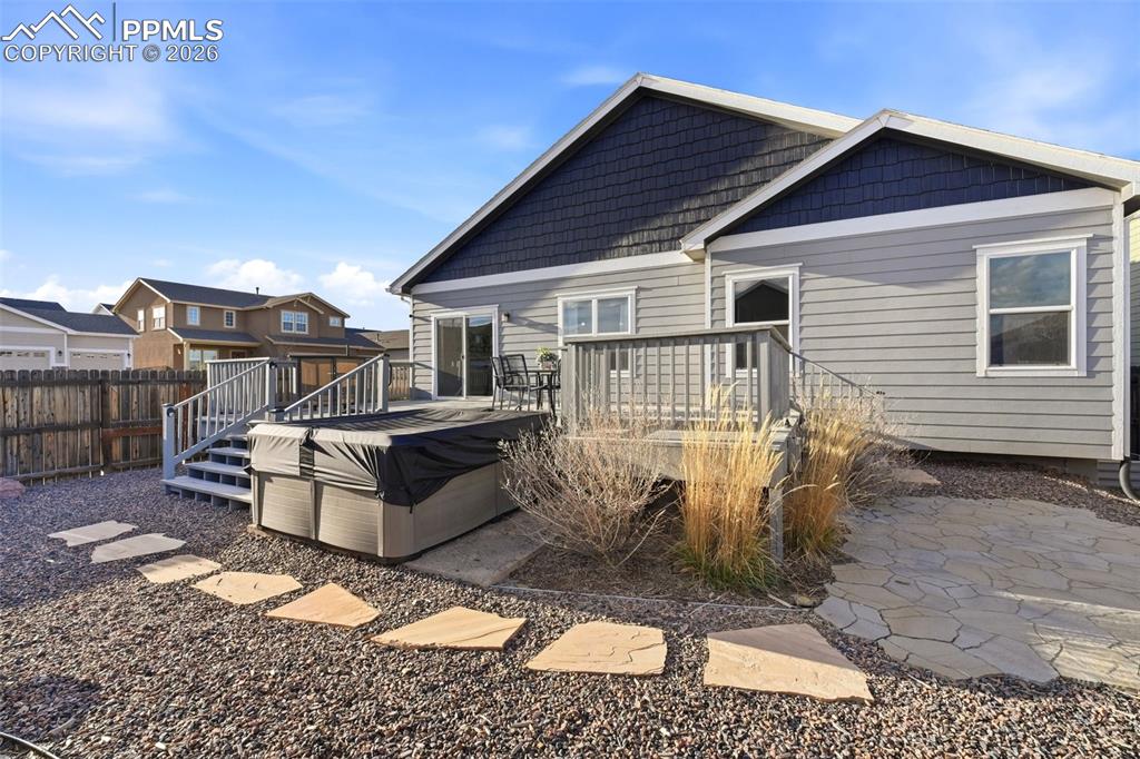Image 43 of 50: Rear view of house with a wooden deck, a patio area, and a hot tub