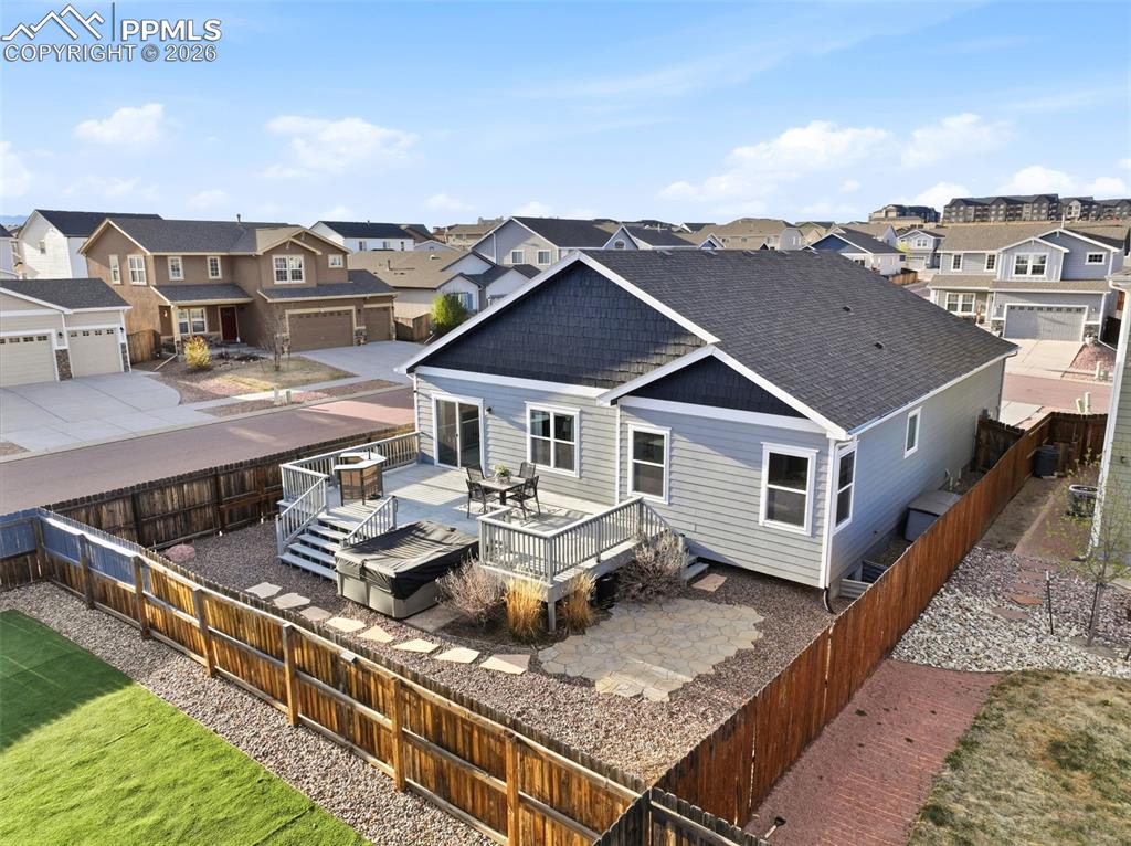 Image 44 of 50: Back of property with a wooden deck, a residential view, a fenced backyard,