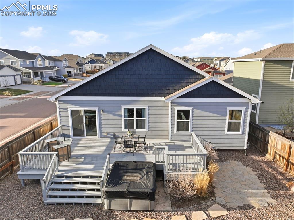 Image 45 of 50: Back of house featuring a residential view, a fenced backyard, an outdoor l
