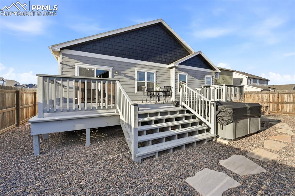 Image 47 of 50: Back of property featuring a fenced backyard and a wooden deck